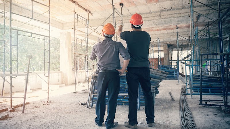 Engineer discussing with foreman about project in building construction site